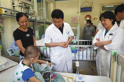 北京儿童医院儿童肿瘤科主任王焕民和医生们对肿瘤患儿病情进行会诊。